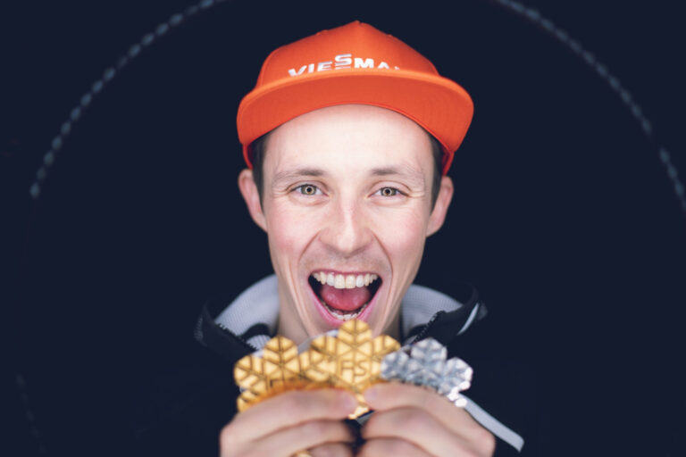 Eric Frenzel hält bei der Weltmeisterschaft in Seefeld zwei goldene und eine silberne FIS Medaillen in den Händen
