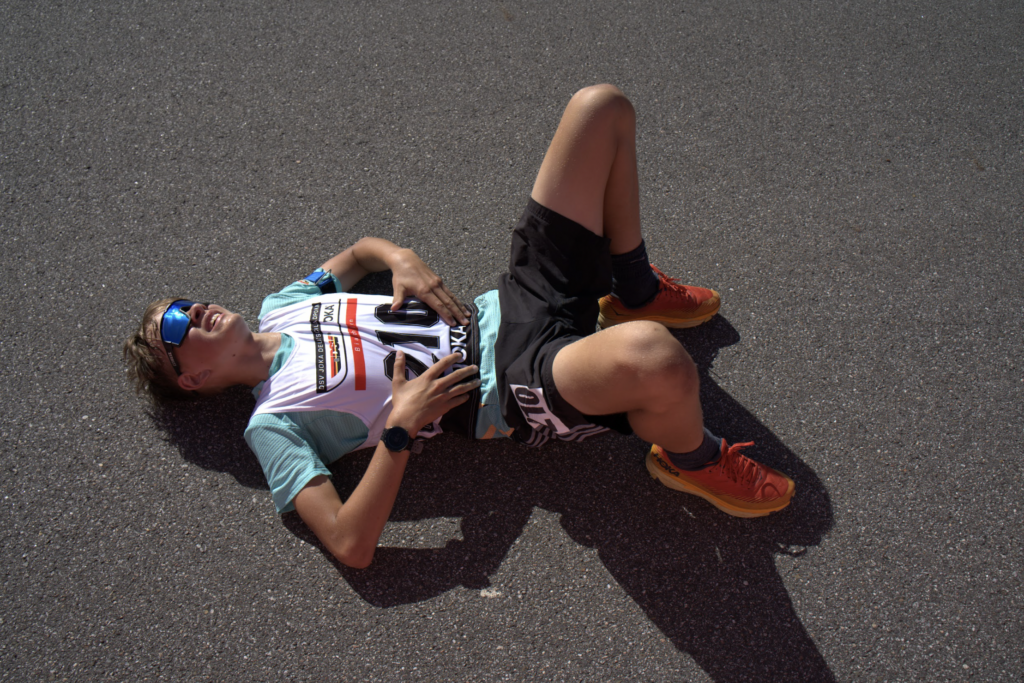 Ein junger Biathlet liegt nach dem Crosslauf beim DSV JOKA Deutschlandpokal Biathlon am Arber erschöpft auf dem Boden